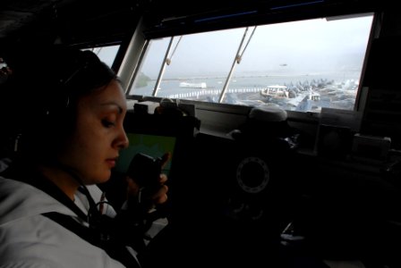 US Navy 081117-N-3610L-205 Quartermaster 3rd Class Desiree Semma uses a sound-powered phone to relay messages and update a plotting change photo