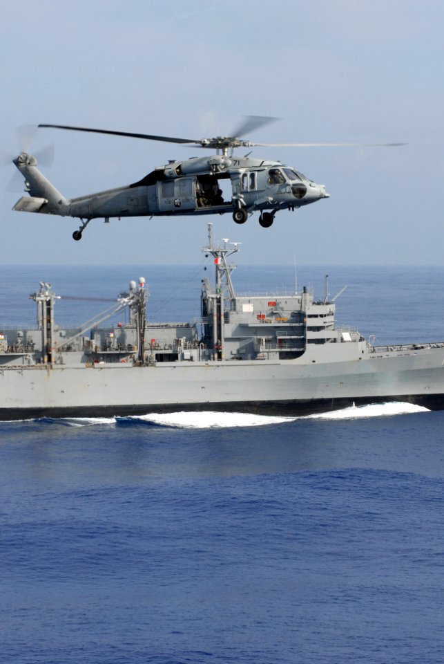 US Navy 081114-N-4995K-047 An MH-60S Sea Hawk flies past the Military Sealift Command fast combat support ship USNS Bridge (T-AOE 10)