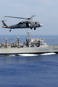 US Navy 081114-N-4995K-047 An MH-60S Sea Hawk flies past the Military Sealift Command fast combat support ship USNS Bridge (T-AOE 10)