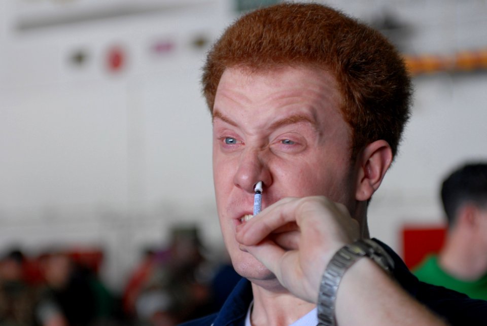 US Navy 081112-N-9132C-035 Machinist's Mate 2nd Class Lucas Carthew, from Sacramento, Calif., inhales a mist form of the flu vaccination aboard the Nimitz-class aircraft carrier USS Ronald Reagan (CVN 76)