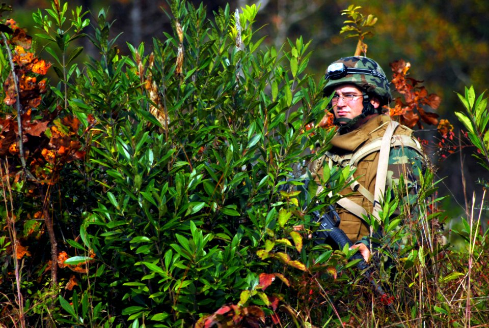 US Navy 081114-N-7367K-013 Equipment Operator Constructionman John Hobbs III remains concealed while fellow Seabees continue performing a security sweep