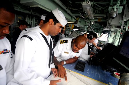 US Navy 100313-N-8335D-010 Lt. Cmdr. Patrick German, right, and Quartermaster 2nd Class David Mora plot the ship's position