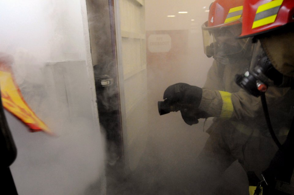 US Navy 081114-N-3659B-510 Sailors assigned to Repair Locker 1F battle a simulated class Bravo fire in a fuel station in hangar bay one during a general quarters drill aboard the aircraft carrier USS Ronald Reagan (CVN 76)