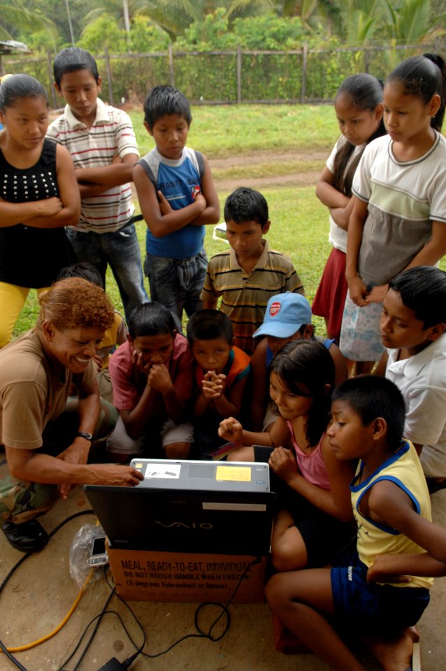 US Navy 081116-N-7544A-093 Lt. Carmen Harmon, a Navy nurse embarked aboard the amphibious assault ship USS Kearsarge (LHD 3), shares a computer game with children