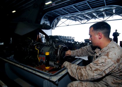 US Navy 081114-N-4236E-048 Cpl. Christopher O'Neal performs maintenance on a jet engine in the hangar bay of the multi-purpose amphibious assault ship USS Iwo Jima (LHD 7)