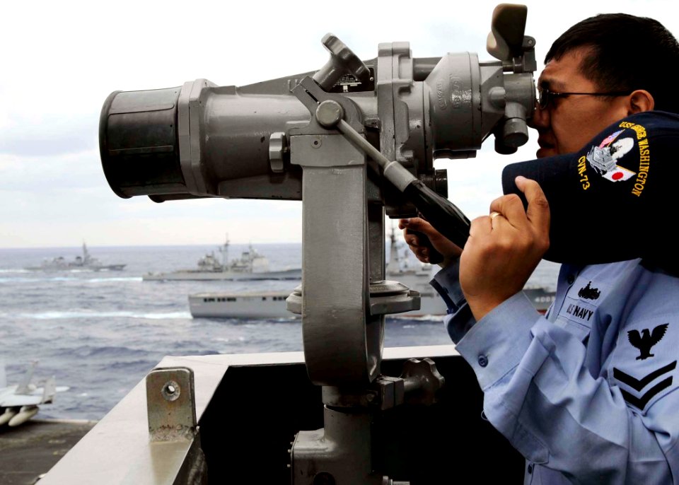 US Navy 081119-N-8534H-099 A Sailor aboard the aircraft carrier USS George Washington (CVN 73) observes the 20-ship formation surrounding George Washington at the culmination of ANNUALEX 2008
