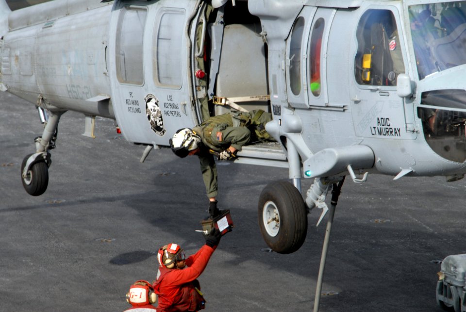 US Navy 081114-N-9132C-082 An aircrewman leans out of an MH-60S Sea Hawk