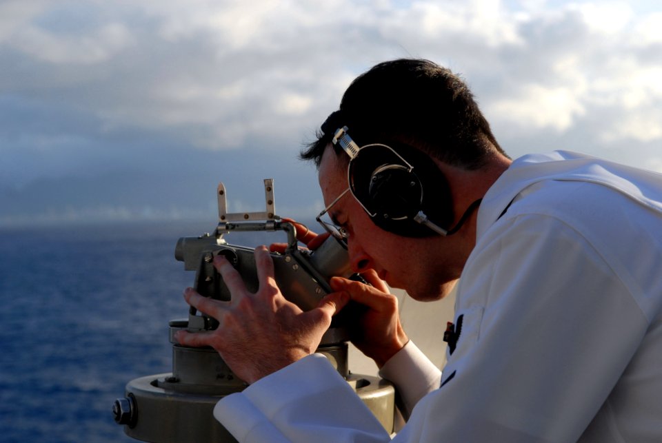 US Navy 081117-N-1635S-001 Quartermaster 3rd Class Christopher Bridges uses an alidade to take bearings from the O-9 level of the Nimitz-class aircraft carrier USS Ronald Reagan (CVN 76)