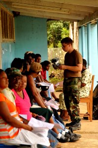US Navy 081117-N-8907D-170 Hospital Corpsman Michael Hagglung talk with patients awaiting eye examinations during medical operations at the Port Kaituma Skills Training Centre photo