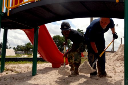 US Navy 081116-N-3595W-132 Aviation Ordnanceman Jason Franklin and Air Force Airman 1st Class Pasha Hughes help build a new playground at the East Ruimveldt Community Center