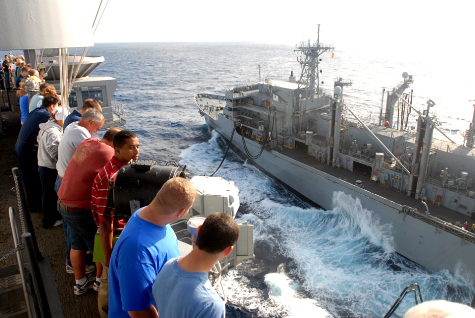 US Navy 081120-N-9132C-048 Tiger Cruise participants look down from the 09 level of USS Ronald Reagan (CVN 76) to see the fast combat support ship USNS Bridge (T-AOE 10) refuel Ronald Reagan during a replenishment at sea