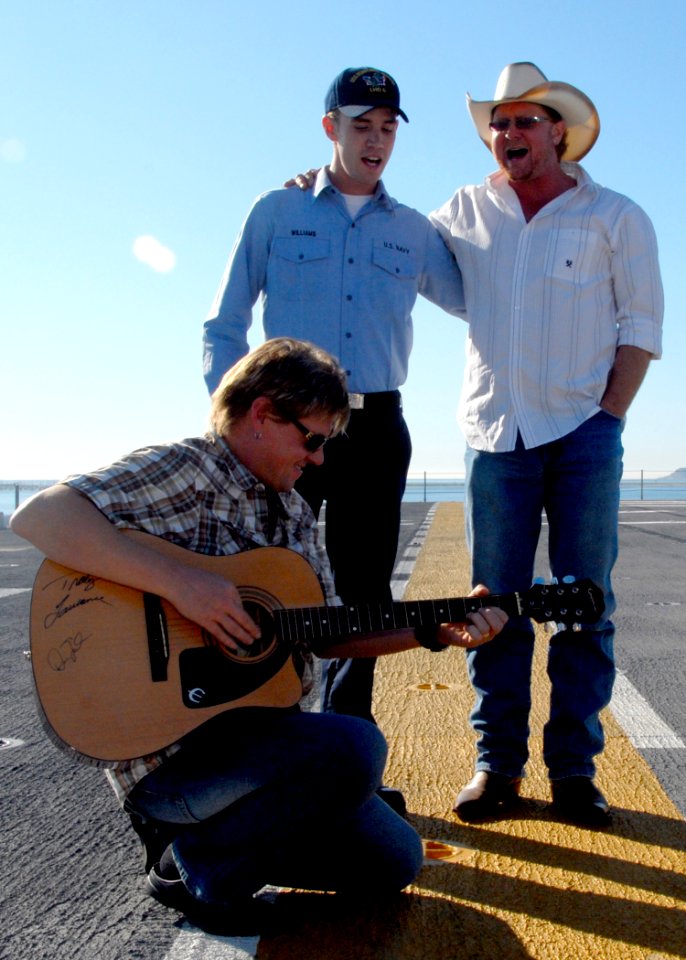 US Navy 081118-N-0515W-162 Country music singer and songwriter Tracy Lawrence, right, sings a duet with Aviation Boatswain's Mate (Handling) 3rd Class David Williams during a tour of the amphibious assault ship USS Bonhomme Ric