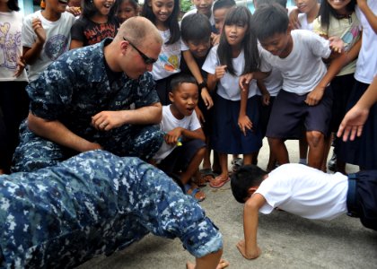 US Navy 101013-N-3620B-094 Aviation Boatswain's Mate (Fuel) Airman Adam Pond oversees a push-up contest