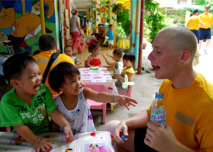 US Navy 100812-N-8539M-209 Crypotlogic Technician 3rd Class Manuel Dominguez practices basic English phrases with children at a Da Nang primary school