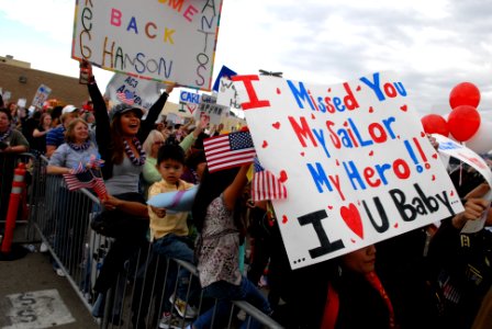 US Navy 081125-N-1635S-001 Friends and family members of Sailors aboard the Nimitz-class aircraft carrier USS Ronald Reagan (CVN 76) celebrate as the ship completes its transit into Naval Air Station North Island photo