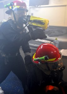US Navy 100909-N-8113T-187 Machinist's Mate 3rd Class Cuong Do, left, uses a Naval firefighting thermal imager (NFTI) to find hotspots