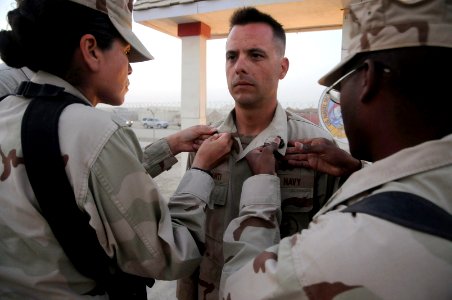 US Navy 100916-N-0475R-137 Chief Equipment Operator Thomas Colesanti, center, assigned to the Naval Mobile Construction Battalion (NMCB) 5, has his