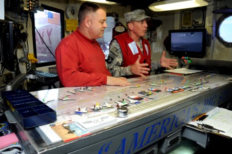 US Navy 081127-N-4584J-008 Gen. David H. Patraeus, Commander, U.S. Central Command (CENTCOM) gets briefed by Flight Deck Handler Lt. Cmdr. Wesley D. Cunningham in Flight Deck Control aboard the aircraft carrier USS Theodore Roo