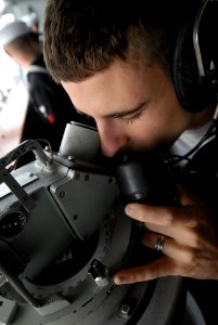 US Navy 081125-N-3610L-110 Quartermaster 3rd Class Michael Cochran uses a sound powered phone and alidade to update navigation aboard the Nimitz-class aircraft carrier USS Ronald Reagan (CVN 76)