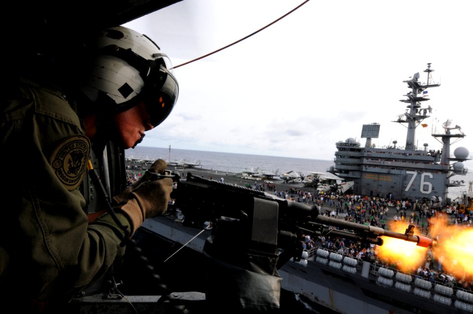 US Navy 081121-N-3659B-202 Naval Aircrewman 2nd Class Keith Holt fires blank rounds from an M-240 machine gun from an SH-60F Seahawk helicopter assigned to the