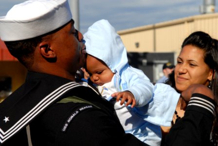 US Navy 081125-N-1635S-005 Culinary Specialist Seaman Tour'e Burt embraces his newborn child upon his return to Naval Station North Island