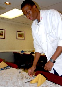 US Navy 081128-N-9900B-003 Culinary Specialist 2nd Class Jamie Scrubb, assigned to Carrier Strike Group 2, positions a place setting in the flag mess aboard the aircraft carrier USS Theodore Roosevelt (CVN 71)