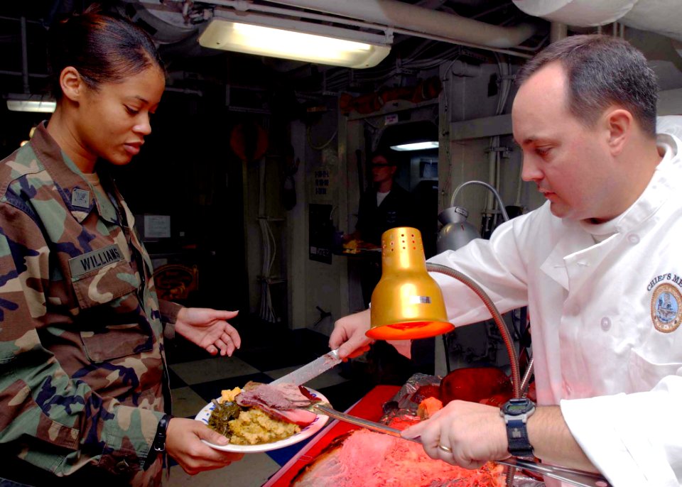 US Navy 081127-N-2456S-033 Cmdr. Aaron Stanley, supply officer aboard the aircraft carrier USS Theodore Roosevelt (CVN 71), serves roast beef to Master-at-Arms 2nd Class Stephanie Williams, from Washington, during a Thanksgivin