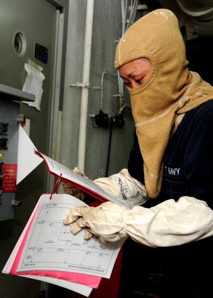 US Navy 101019-N-5538K-010 Machinist's Mate Fireman Jessica Fernandez reviews an engineering operations manual during a damage control drill aboar