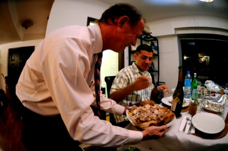 US Navy 081127-N-8546L-113 Meals in the Home volunteer host, Tim Sullivan, holds a plate of freshly cut turkey as Storekeeper 2nd Class Jose Betancourtcantu forks a few slices onto his plate