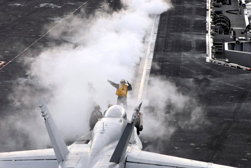 US Navy 081124-N-3610L-187 Aviation Boatswain's Mate (Handling) 2nd Class Diego Salvador directs an F-A-18C Hornet