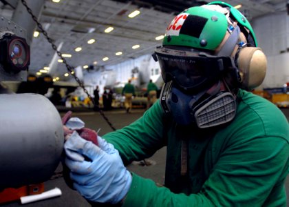 US Navy 081129-N-2456S-026 Aviation Structural Mechanic 1st Class Todd Theobalt, assigned to HS-3, applies paint thinner to a float bag prior to painting an SH-60H Sea Hawk in the hangar bay aboard the aircraft carrier USS Theo