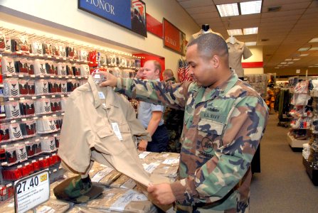 US Navy 081201-N-2468S-003 Ship's Serviceman 2nd Class Charles Clay shops for the new service uniform at the Navy Exchange