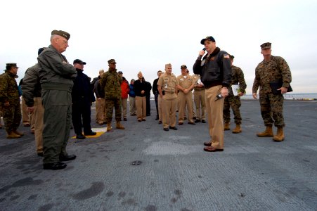 US Navy 081202-N-2636M-120 Cmdr. Michael McMillan speaks about the flight deck to distinguished visitors during a Boots-on-the-Deck visit