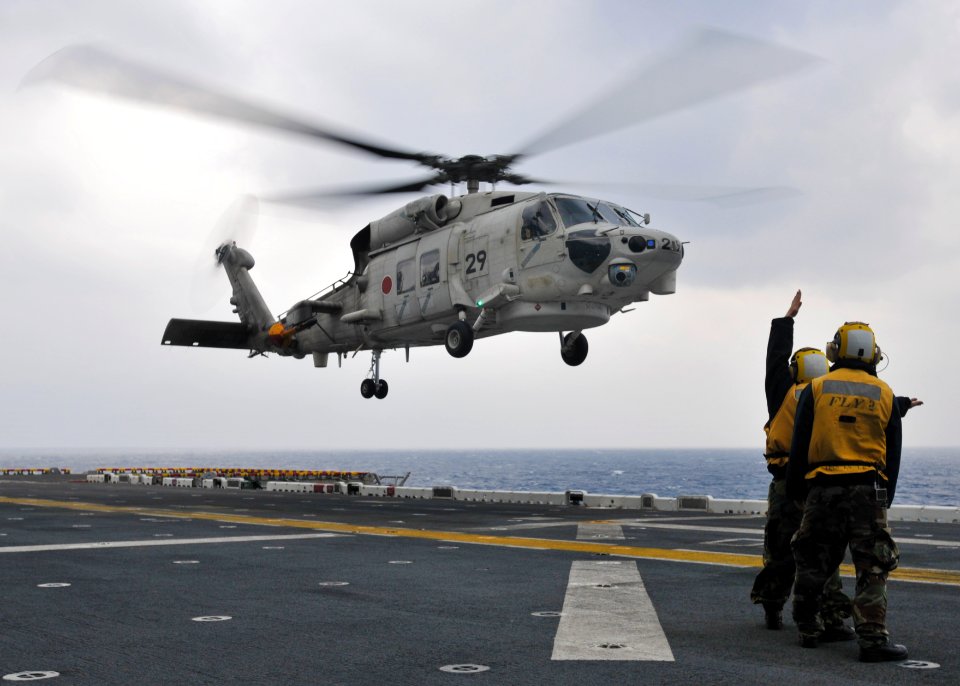 US Navy 101207-N-9950J-107 Aviation boatswain's mates direct the landing of a Japan Maritime Self-Defense Force SH-60K Sea Hawk helicopter