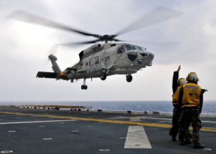 US Navy 101207-N-9950J-107 Aviation boatswain's mates direct the landing of a Japan Maritime Self-Defense Force SH-60K Sea Hawk helicopter