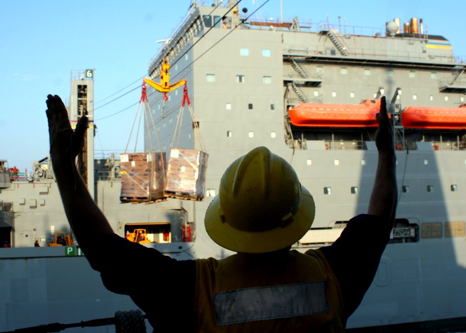 US Navy 081130-N-6764G-304 Boatswain's Mate 2nd Class Jeff Sparks signals for supplies to be sent from USNS Lewis and Clark (T-AKE 1)