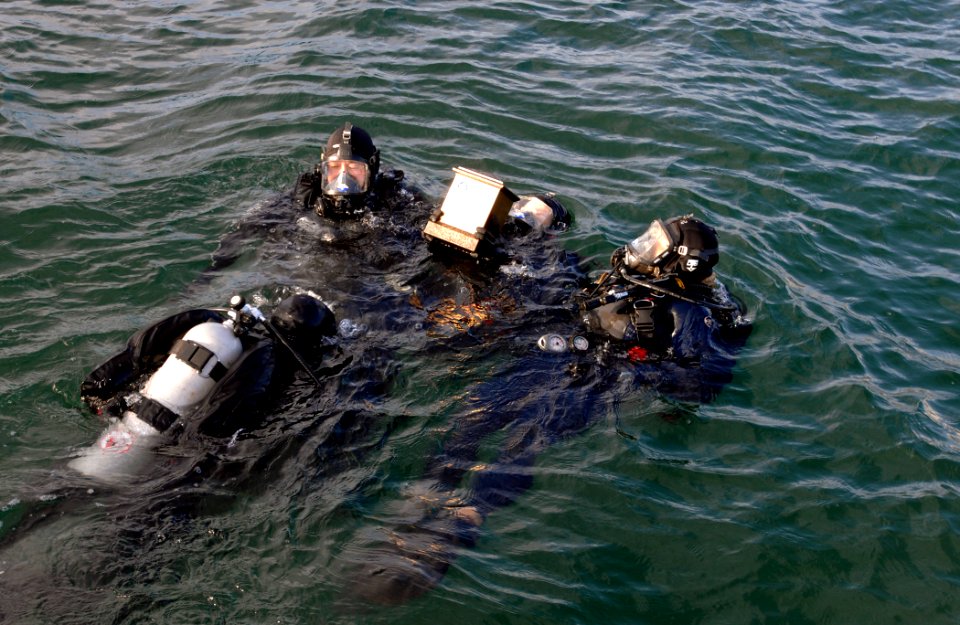 US Navy 081207-N-0535P-253 National Park Service divers hold the cremains of Seaman 1st Class Charles Guerin Jr. during an interment ceremony aboard the USS Arizona Memorial