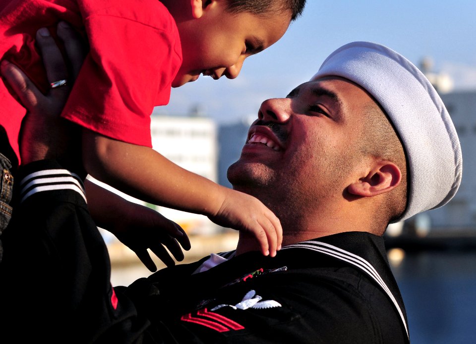 US Navy 081202-N-0807W-488 Hospital Corpsman 2nd Class Arturo J. Adame holds his son during a homecoming celebration for the amphibious transport dock ship USS Denver (LPD 9)to Fleet Activities Sasebo