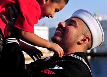 US Navy 081202-N-0807W-488 Hospital Corpsman 2nd Class Arturo J. Adame holds his son during a homecoming celebration for the amphibious transport dock ship USS Denver (LPD 9)to Fleet Activities Sasebo