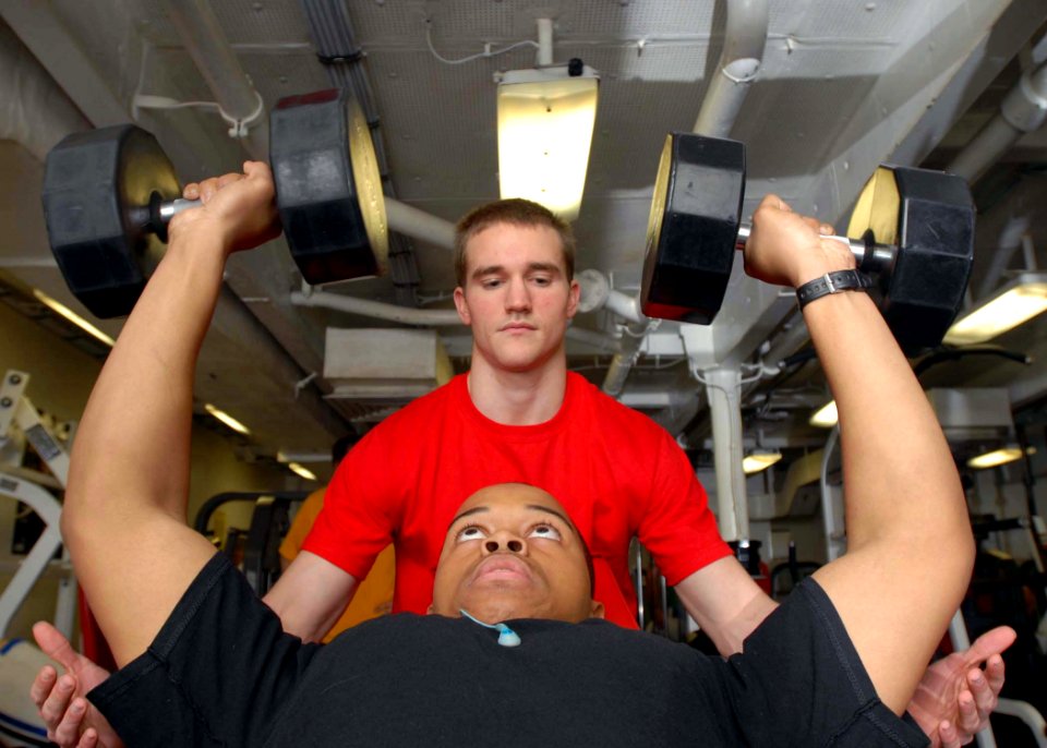 US Navy 081206-N-2456S-006 Aviation Boatswain's Mate (Fuel) Airman Joseph Haefner ssists Aviation Boatswain's Mate (Fuel) Airman Nicholas Bell with lifting 60-pound weights