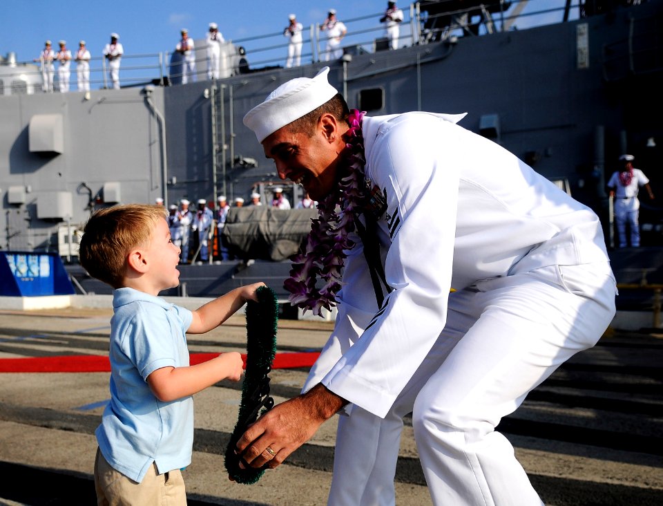US Navy 101214-N-7498L-198 Boatswain's Mate 1st Class Frank Mortensen greets his son on the pier after returning to Joint Base Pearl Harbor-Hickam