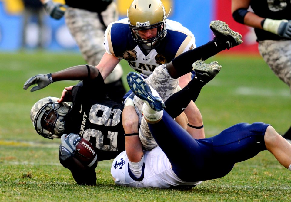 US Navy 081206-N-5345W-601 U.S. Military Academy running back Tony Dace (^28) is tacked for a loss by U.S. Naval Academy midshipmen