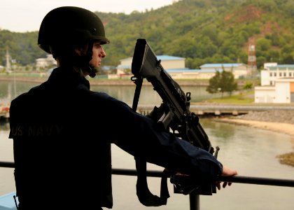US Navy 110128-N-5620H-445 Gunner's Mate 2nd Class Aron Miltenberger stands watch of Sepangar Bay aboard USS Frank Cable (AS 40)