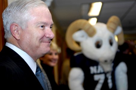 US Navy 081204-N-2855B-048 Secretary of Defense Robert M. Gates smiles as the U.S. Naval Academy Band and cheerleaders stop outside his office during their annual pep rally through the halls of the Pentagon