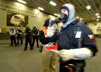 US Navy 081204-N-2636M-032 Aviation Boatswain's Mate (Handling) 3rd Class Ciro Mendoza, from Phoenix, talks on the radio during a hangar deck fire drill