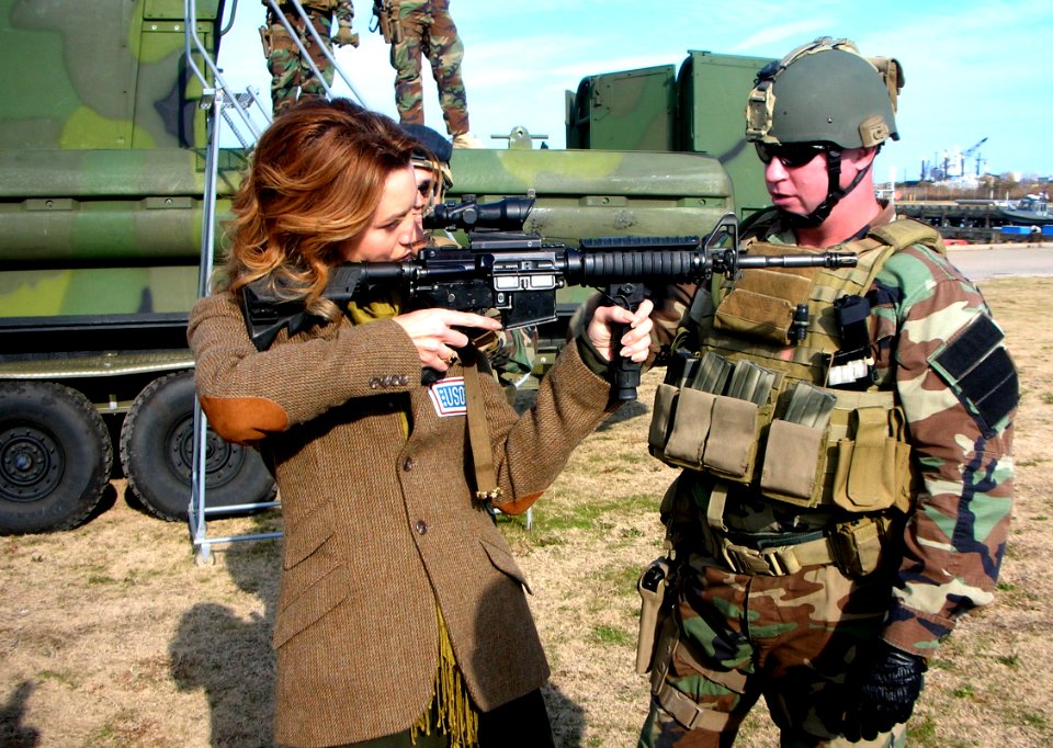 US Navy 081206-N-3346C-012 Chief Master-at-Arms Michael Minotto explains the functions of the M4 Battle Rifle to actress Hilarie Burton