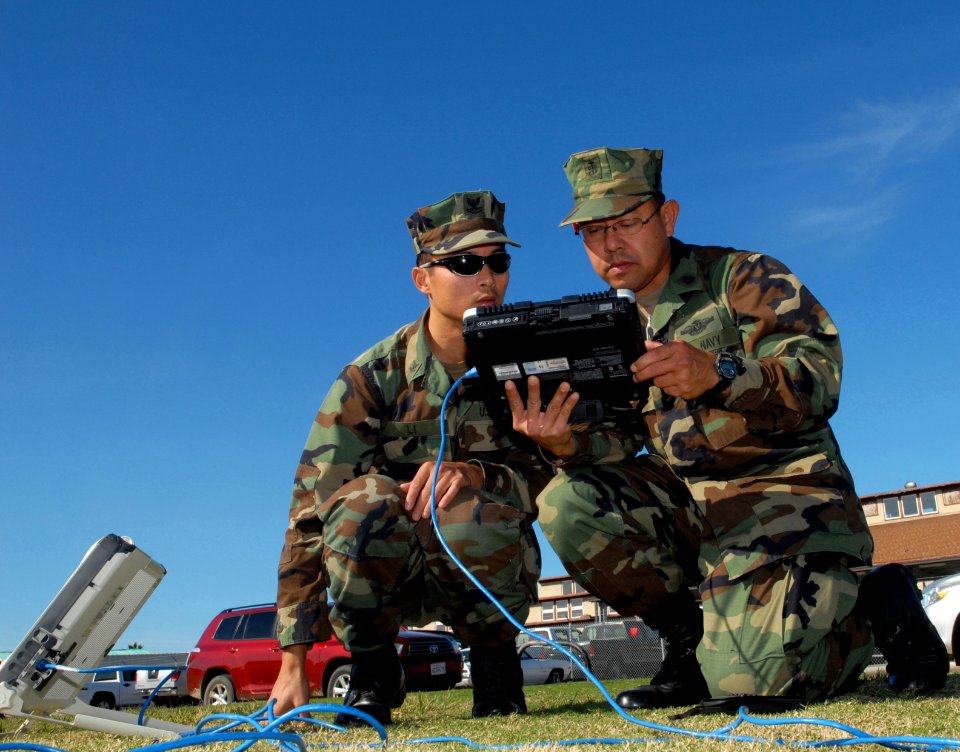 US Navy 081210-N-1226D-034 Engineman 2nd Class Zhiwei Li nd Chief Hospital Corpsman Kevin Avila use a Broadband Global Area Network portable satellite terminal