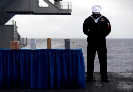 US Navy 101227-N-7981E-989 Hospital Corpsman 1st Class Kenneth Matthews bows his head in prayer during the benediction for a burial at sea