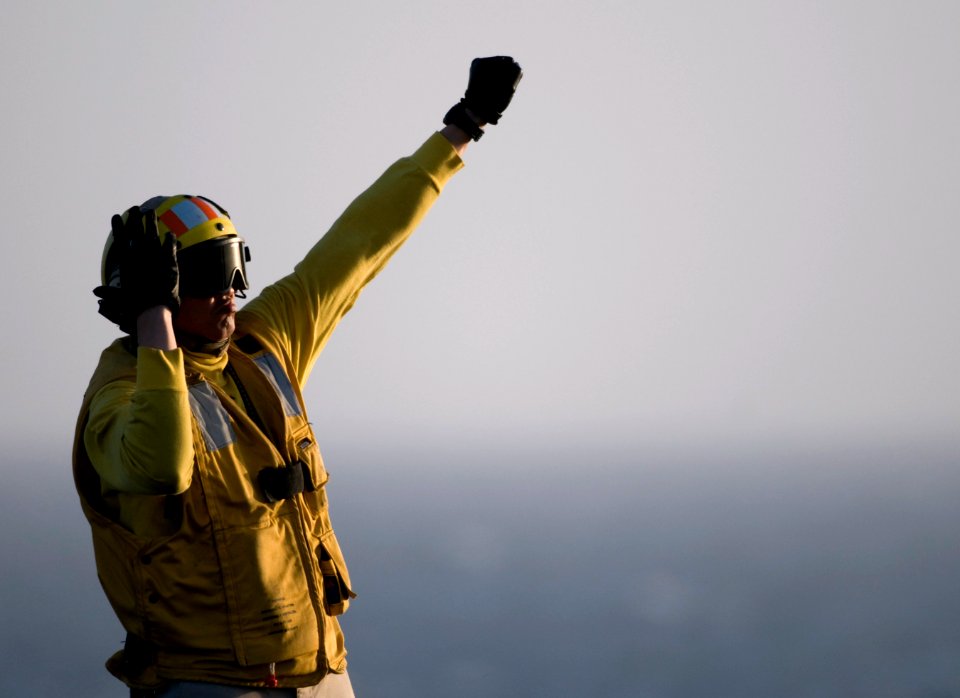 US Navy 110326-N-6505H-365 Chief Aviation Boatswain's Mate (Handling) Stanley Bolinger directs an aircraft aboard USS Carl Vinson (CVN 70)