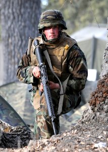 US Navy 081211-N-9584N-144 Steel Worker Constructionman Apprentice Isaiah Halverson scans the tree line during an enemy small arms assault on his position during a field training exercise at Fort Hunter Liggett